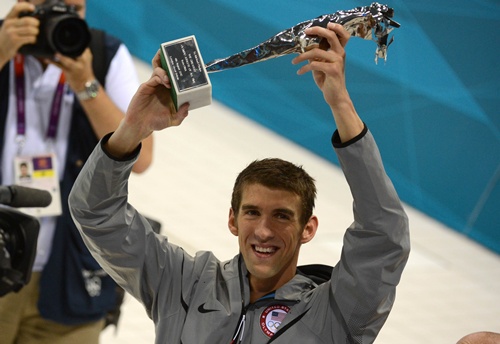 London, Greater London, UNITED KINGDOM: US swimmer Michael Phelps smiles as he holds his trophy of the greatest olympic athlete of all time after he won gold in the mens 4x100m medley relay final during the swimming event at the London 2012 Olympic Games on August 4, 2012 in London. AFP PHOTO/Christophe Simon