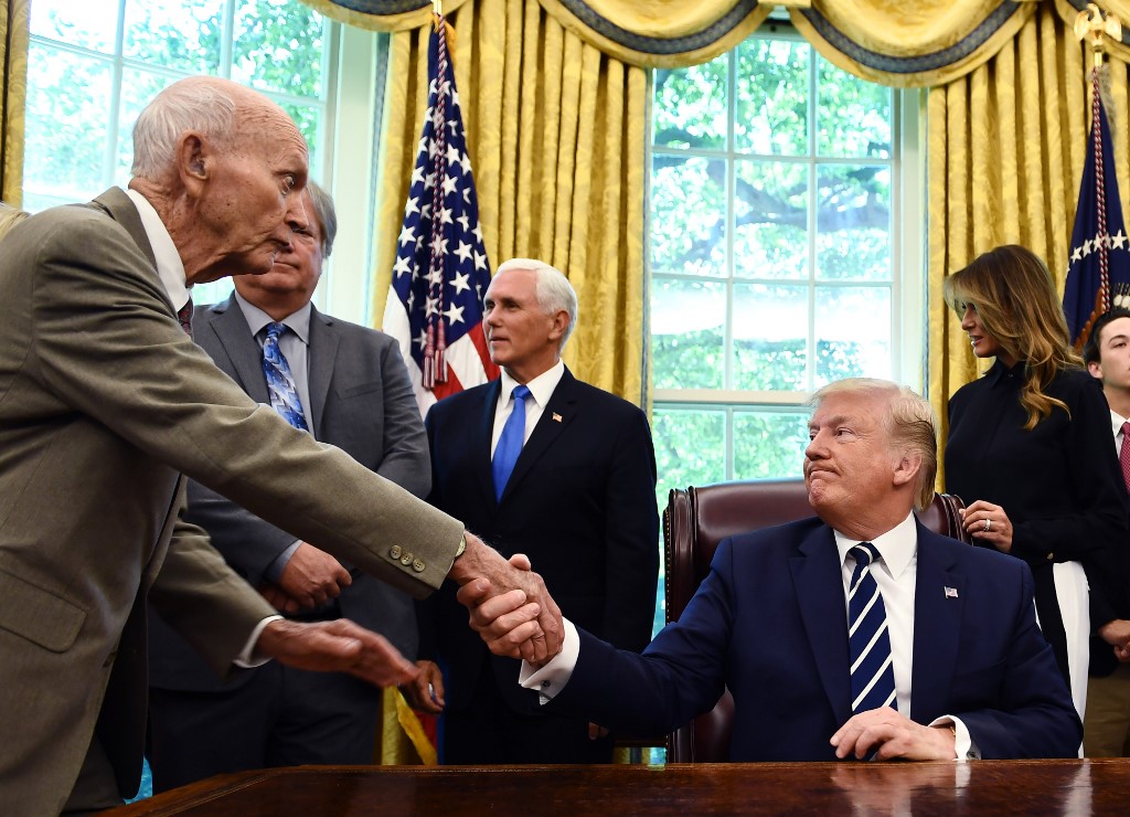 ไมเคิล คอลลินส์ จับมือกับ นาย โดนัลด์ ทรัมป์ ประธานาธิบดีสหรัฐฯ (Brendan Smialowski / AFP)
