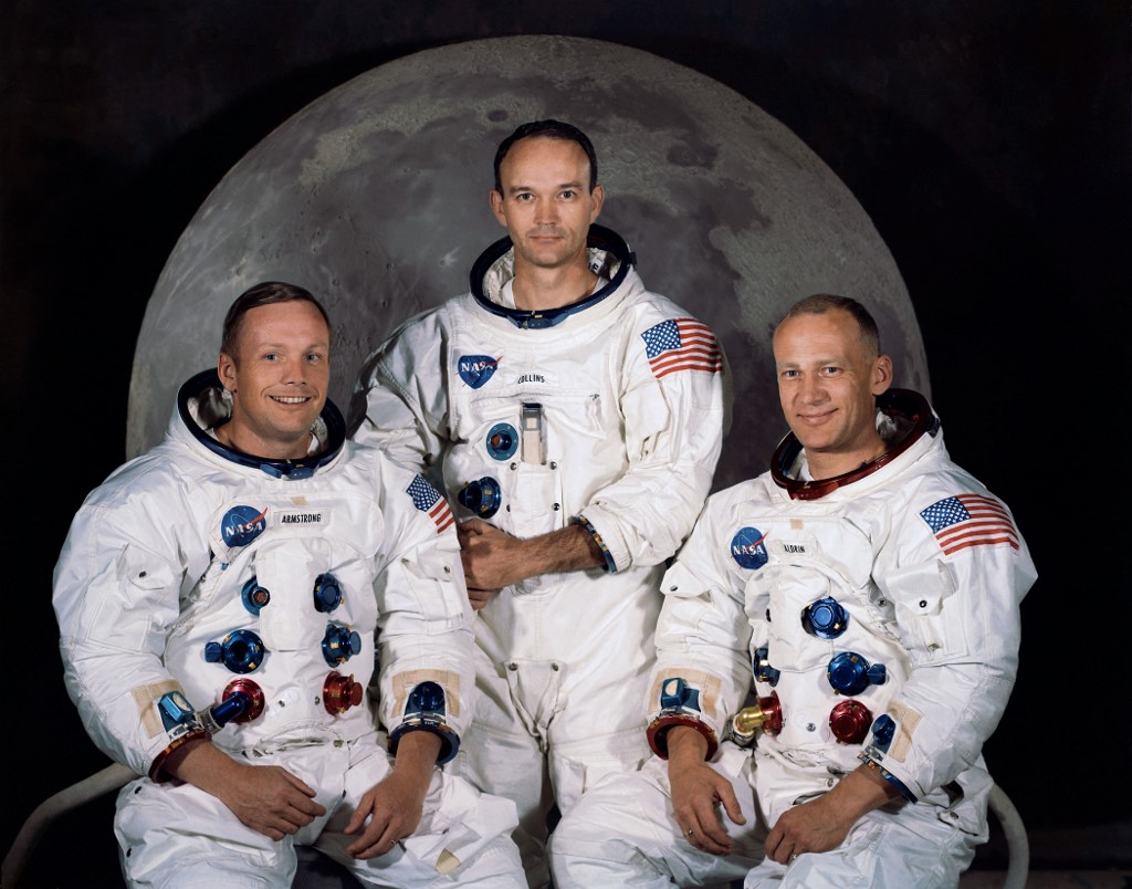 ภาพถ่ายอย่างเป็นทางการของลูกเรืออะพอลโล 11 จากศูนย์อวกาศเคนเนดี (Kennedy Space Center) เมื่อ 30 มี.ค.1969 (ซ้ายไปขวา) นีล อาร์มสตรอง ในฐานะผู้บังคับการ , ไมเคิล คอลลินส์ ในฐานะผู้ขับโมดูล (ยืน) และ บัซ อัลดริน ในฐานะผู้ขับโมดูลดวงจันทร์ (HO / NASA / AFP )