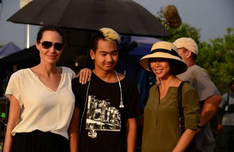 แองเจลินา โจลี (ซ้าย) และ Maddox (กลาง) เด็กชาวกัมพูชาที่โจลีรับเป็นลูกบุญธรรม และ Loung Ung ผู้เขียนบันทึก  First They Killed My Father  ถ่ายภาพหมู่ขณะถ่ายทำภาพยนตร์ First They Killed My Father  (แฟ้มภาพจากอินเตอร์เน็ต ) 