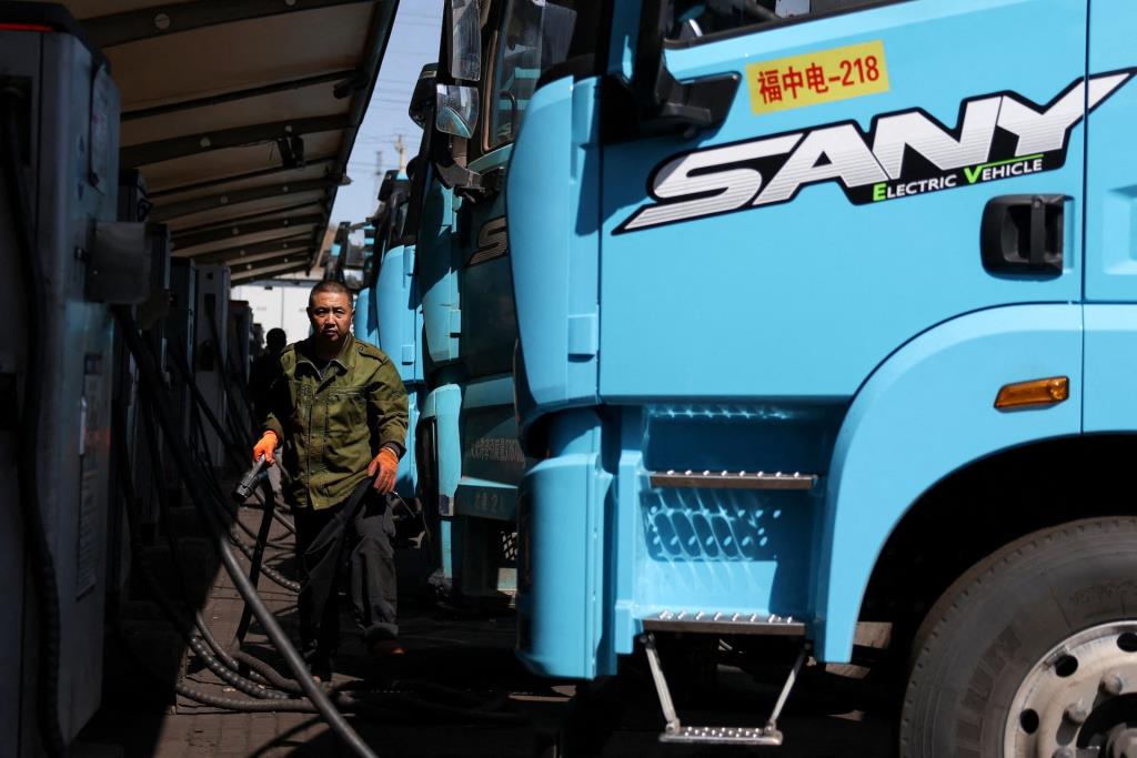 คนขับรถกำลังชาร์จรถบรรทุกไฟฟ้าของ Sany ที่ศูนย์ซ่อมบำรุง ในเมืองถังซาน มณฑลเหอเป่ย ประเทศจีน เมื่อวันที่ 1 เมษายน 2569 – ภาพ : รอยเตอร์