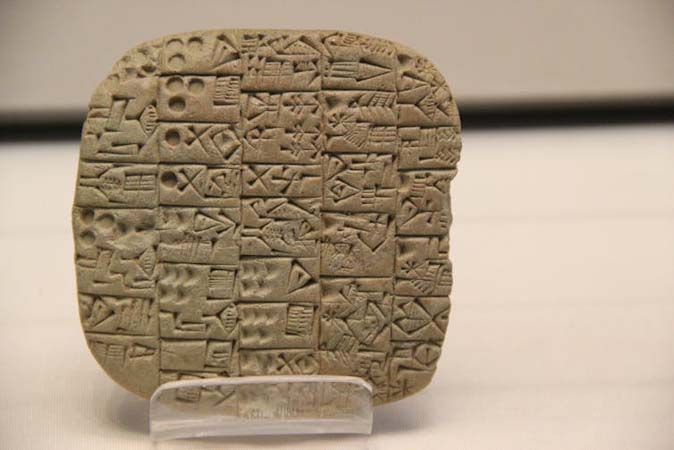 อักษรรูปลิ่ม (cuneiform) ที่แกะสลักจากแผ่นดินเหนียว ภาพจาก Gary Todd/Flickr