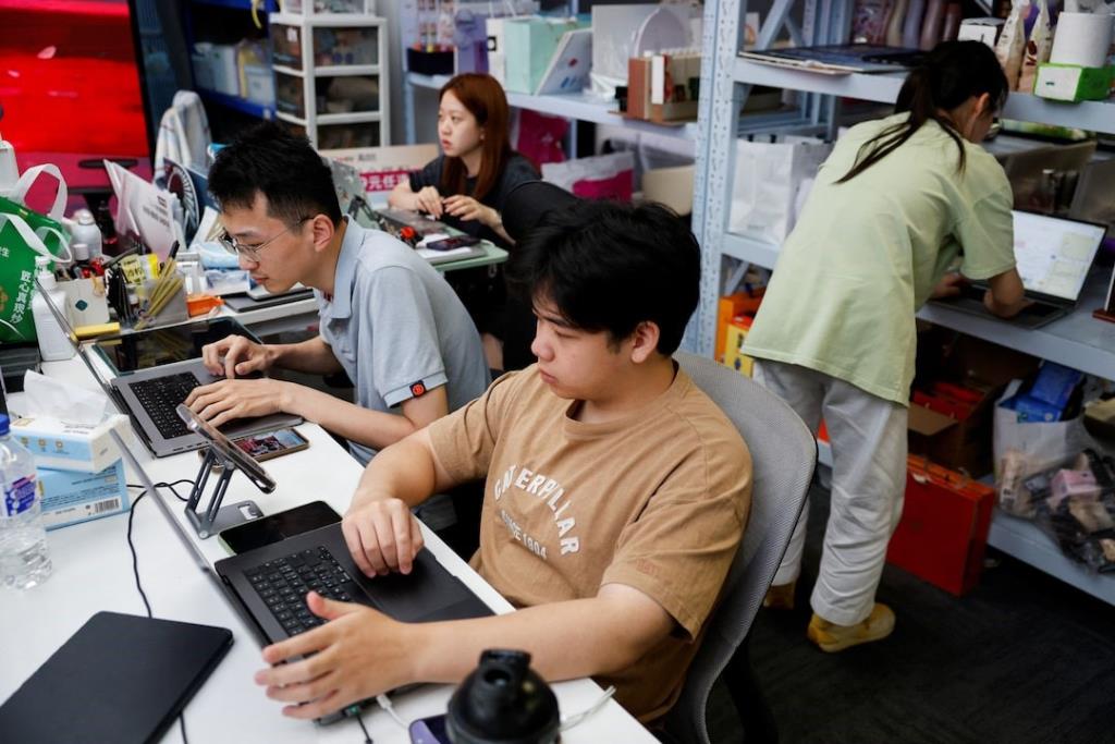 พนักงานของบริษัท MeiONE ทำงานหน้าคอมพิวเตอร์ระหว่างการถ่ายทอดสดที่สำนักงานใหญ่ของบริษัทในนครเซี่ยงไฮ้ ประเทศจีน เมื่อวันที่ 7 กันยายน 2569 - ภาพ : รอยเตอร์