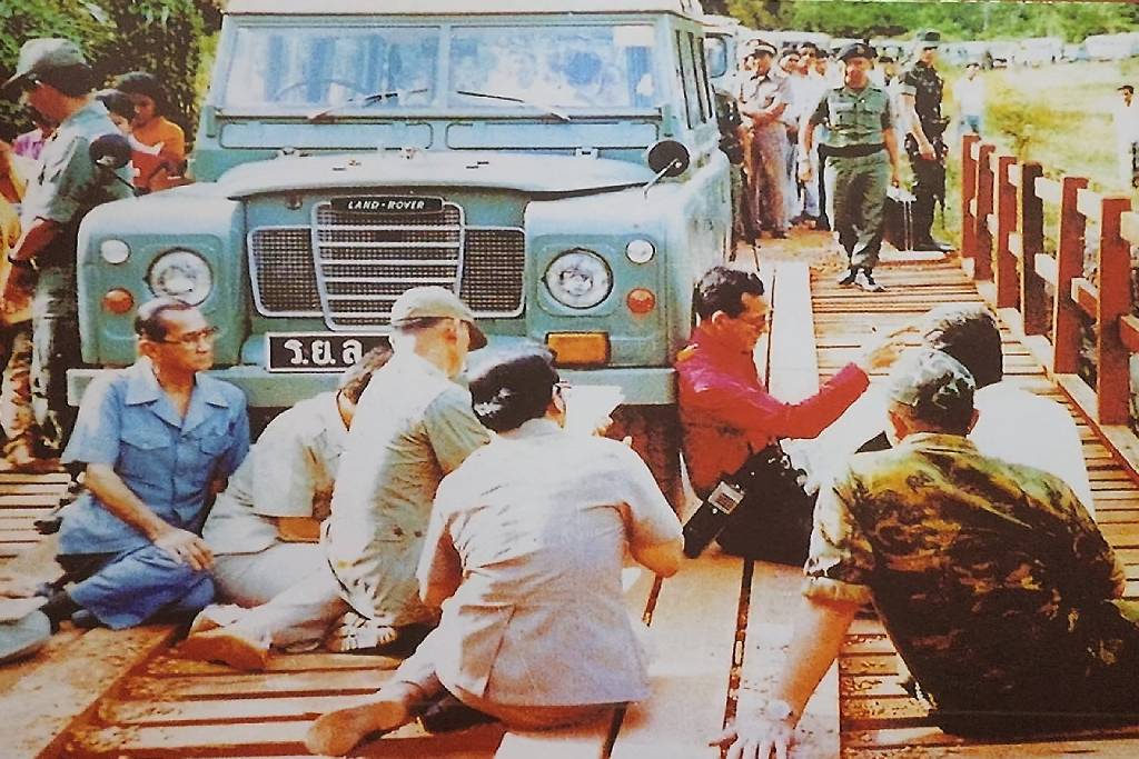 ภาพแห่งความทรงจำ ร.๙ ทรงประทับนั่งพิงรถยนต์พระที่นั่ง เพื่อตรัสถามถึงความเดือดร้อนของพสกนิกรอย่างไม่ถือพระองค์ (ภาพ : ศูนย์การเรียนรู้นันทสิปปาคาร)