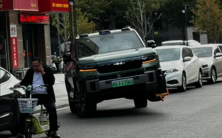 BYD Fang Cheng Bao Bao 8 พร้อมกับที่ล็อกล้อที่ติดอยู่กับล้อหน้าซ้ายที่ยกสูงขึ้น