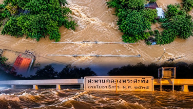 สระแก้ววิกฤต! น้ำตัดขาดสะพานคลองพระสะทึง รถผ่านไม่ได้ หญิงท้องแก่ติดค้าง เร่งลำเลียงด้วยรถไถ